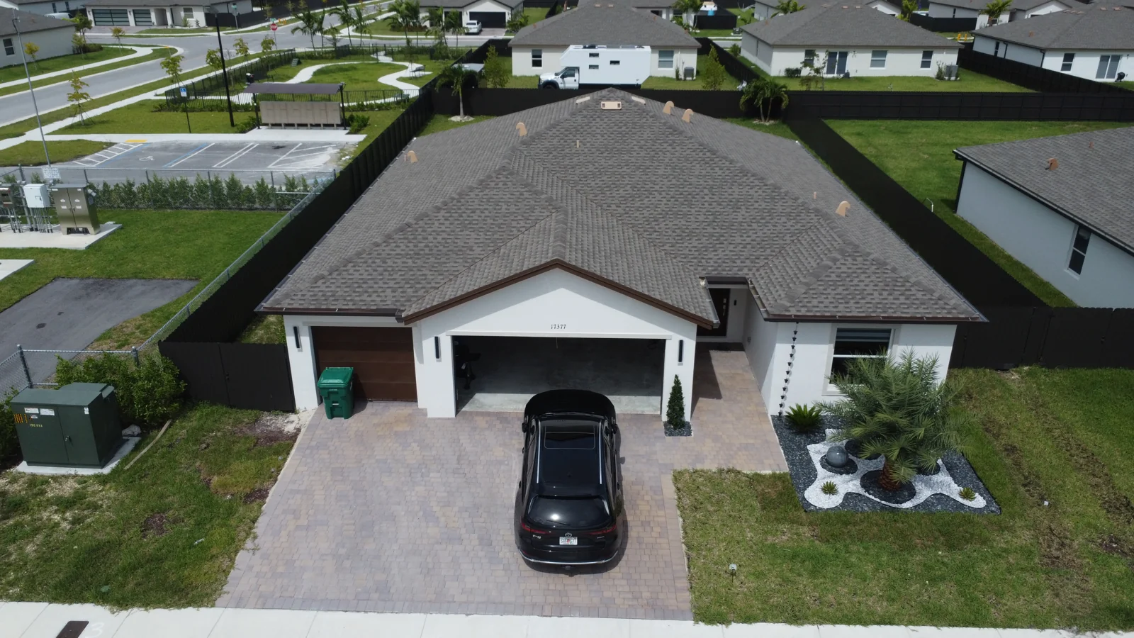 Elevated view of a tile-roof home showing its rooflines and driveway
