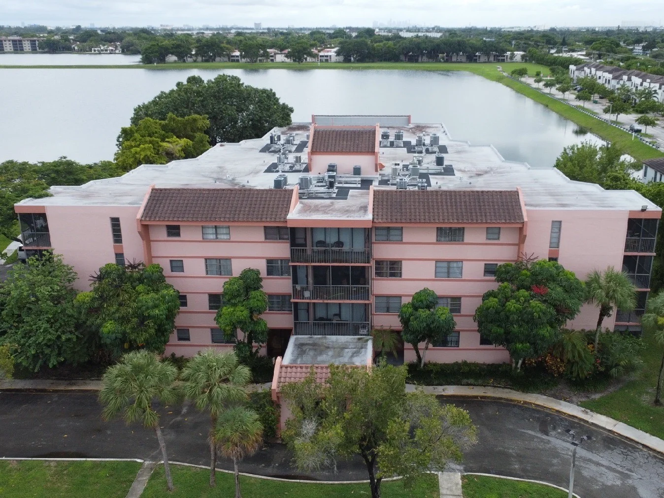 Aerial view of a multi-story building showing rooftop equipment and a nearby lake
