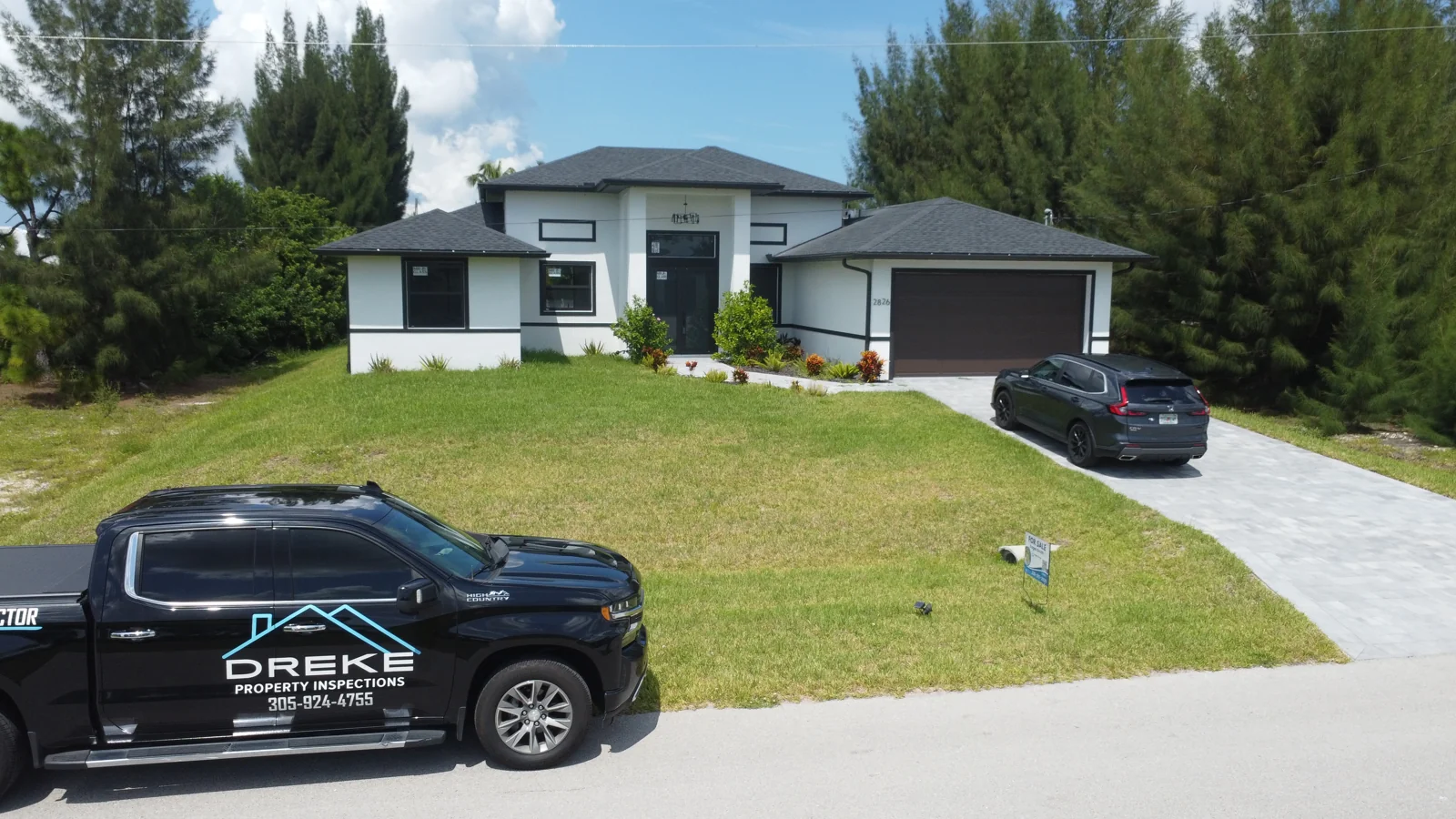 DREKE Property Inspections branded truck parked outside a two-story home