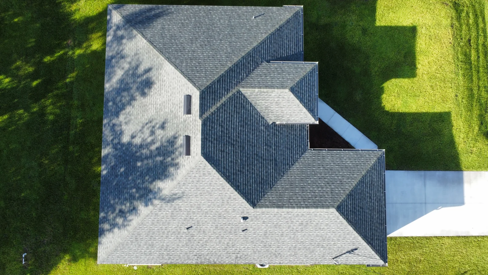 Overhead view of a home showing the roof layout and adjoining lawn